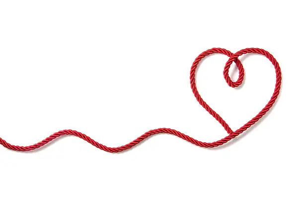 Heart shaped red rope on white background
