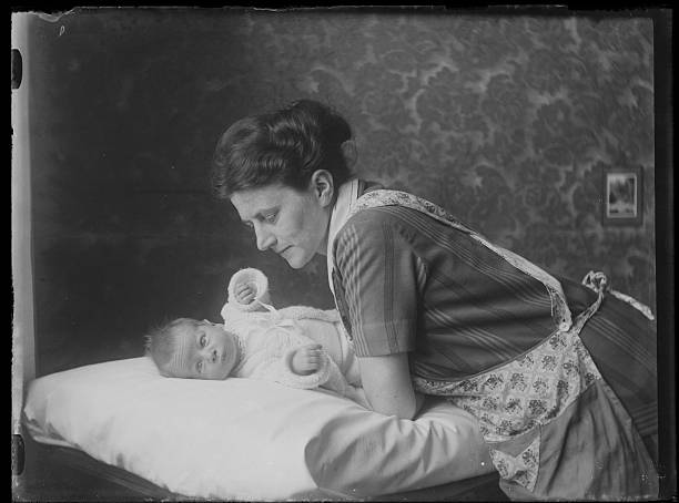 černobílá fotografie pečující matky naklánějící se nad svým dítětem - soukromí fotky - stock snímky, obrázky a fotky