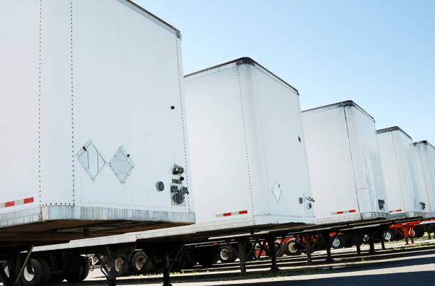 Semi truck trailers Row of white semi truck trailers on a clear blue sky. Check my transportation lightbox for more trucks. trailer stock pictures, royalty-free photos & images