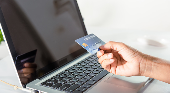 Online shopping. Woman hands holding credit card and using laptop with product purchase at home, female register via credit cards on computer to make electronic payment security online