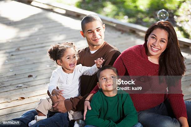 Joven Familia Hispana En El Parque Foto de stock y más banco de imágenes de Familia - Familia, Felicidad, Aire libre