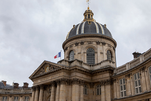 Paris, France - June 6, 2012: Front wall of the Council of State with its French flags and European. The French Council of State is a public institution which sits in the Palais-Royal in Paris since 1875.