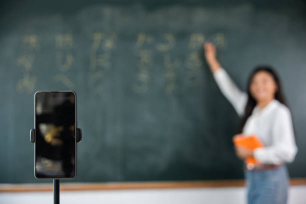 istock Asian teacher teach on board while have blackboard lecture online through smartphone in classroom 1849165567