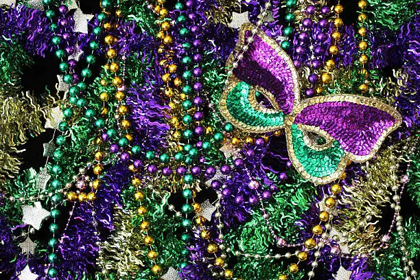 Mardi Gras background with beads and other shiny things in Mardi Gras colors