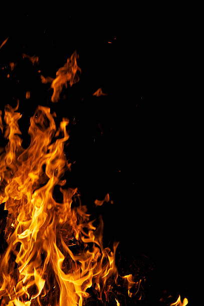 hoguera amarillo llamas de fuego en fondo negro con espacio de copia - flaming torch fire flame sport torch fotografías e imágenes de stock