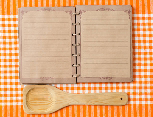 istock Wooden spoon and old notebook on orange tableclot 184917210