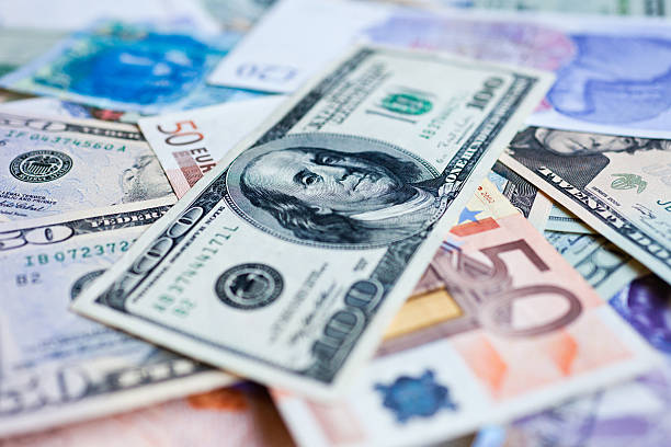 Foreign currency Foreign currency with an American hundred dollar bill on top. Shallow depth of field. european union euro note stock pictures, royalty-free photos & images
