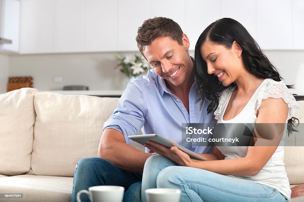 Casal sorridente usando um tablet digital - Foto de stock de 20-24 Anos royalty-free