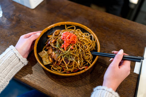 istock Woman using chopstick to eat noodles in a restaurant 1849179959