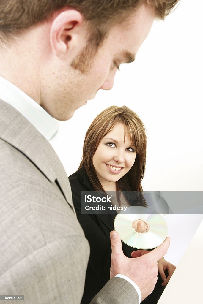 Data Sharing Man handing woman a CD Adult Stock Photo