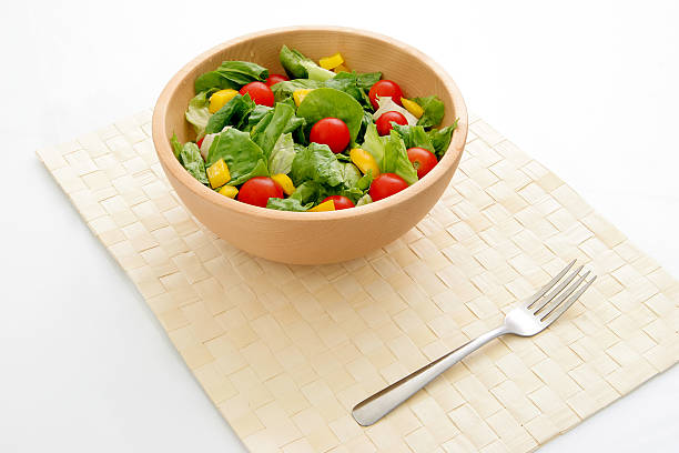 Picture of green leafy salad in a wooden bowl.