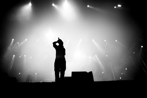 Silhouette of hip hop singer on stage. 