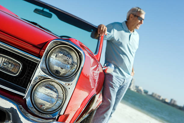 istock Senior with classic convertible car 184918793