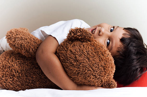Toddler hugging his teddy bear.