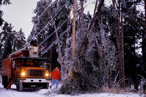 a power company worker repairs downed power lines after a Minnesota winter storm