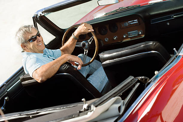 istock Senior with classic convertible car 184919374