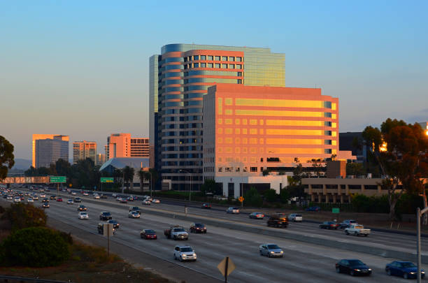 Irvine city skyline and freeway at sunset Irvine, California city skyline with the 405 freeway in the foreground at sunset.  Irvine is located in Orange County. highway 405 photos stock pictures, royalty-free photos & images