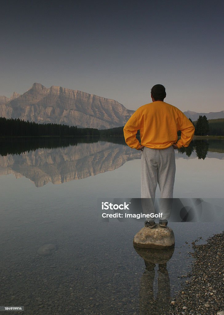 Ein Mann balancing auf einem rock mit Blick auf die Berge - Lizenzfrei Aktiver Lebensstil Stock-Foto