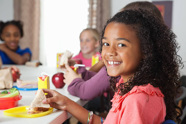 istock Little girl having lunch in school classroom 184920128