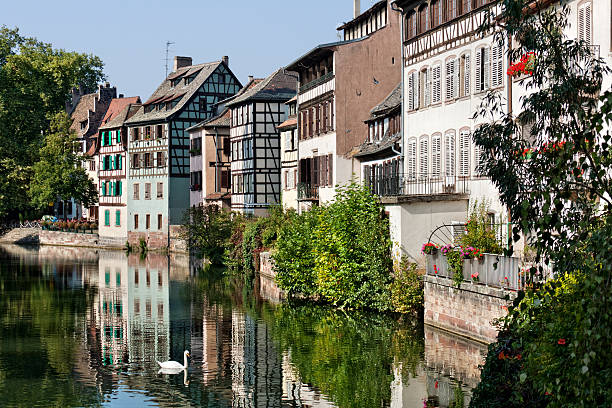 Landmark in Strasbourg - The Quarter Petite France "The Old Town of the french city Strasbourg, ( Alsace, France ). Quarter Petite France - a local landmark and UNESCO World Heritage. View onto ancient half-timbered houses at the waterfront. Warm light of a september morning" petite france strasbourg stock pictures, royalty-free photos & images