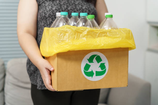 istock Home recycle eco green zero concept Woman throwing empty plastic bottle in recycling bin with yellow garbage bags at home. 1849202733