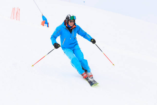 aktiver lebensstil, vital senior herren schneeskifahrer, skifahren, genießen in skigebieten. skicarven mit hoher geschwindigkeit vor blauem himmel. - skiing point of view stock-fotos und bilder