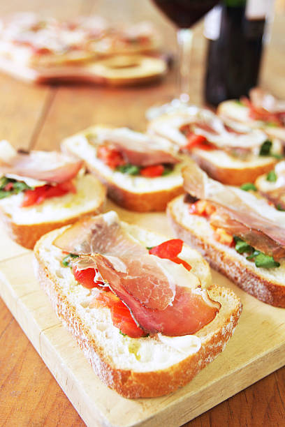 istock Wooden table with bruschetta with prosciutto buffet and red wine 184920666