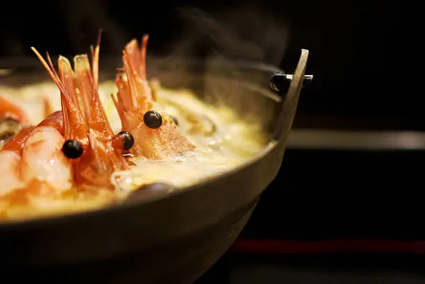 Steam rising from a hotpot of seafood that is cooking slowly to release all the seafood flavors