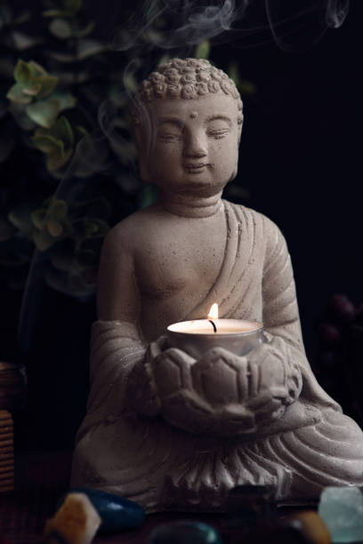 istock stone statue of buddha with a candle 1849211915