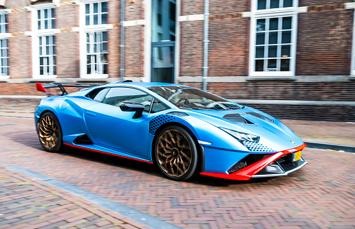 Lamborghini Huracán STO sports car driving on a street in Zwolle, Netherlands. The STO is a high performance edition of the Lambo Huracan with extreme aerodynamics, track-honed handling dynamics, lightweight contents and a high performing V10 engine. Photo with motion blur emphasizing the speed of the car.