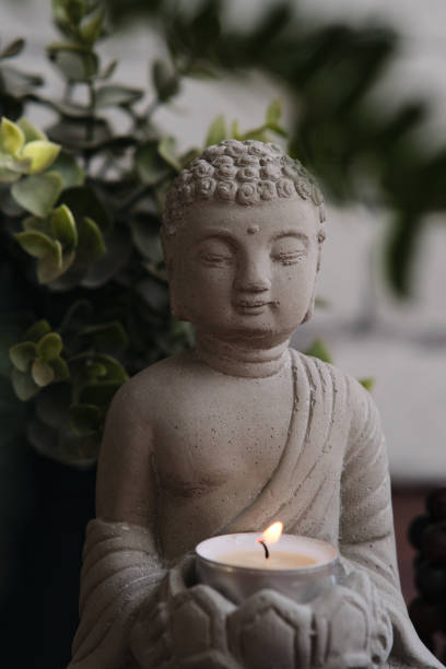 istock stone statue of buddha with a candle 1849213637
