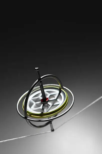 A spinning gyroscope balancing on a string.
