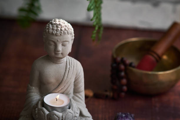istock stone statue of buddha with a candle 1849214474