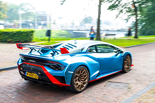 Lamborghini Huracán STO sports car driving on a street in Zwolle, Netherlands. The STO is a high performance edition of the Lambo Huracan with extreme aerodynamics, track-honed handling dynamics, lightweight contents and a high performing V10 engine. Photo with motion blur emphasizing the speed of the car.