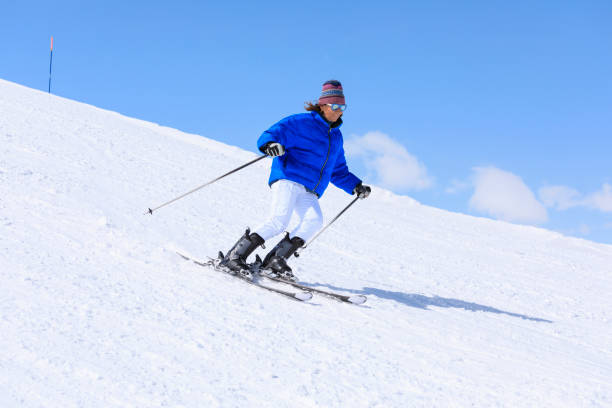 stile di vita attivo, vital sciatrice da neve femminile, godendo su stazioni sciistiche soleggiate. sci carving ad alta velocità contro il cielo blu. - skiing point of view foto e immagini stock