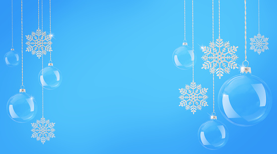 Glowing Christmas balls and snowflakes hanging against blue abstract background. Christmas festive banner