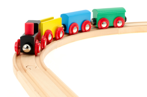 Baby kids toys frame background. Wooden railway with train and colorful sustainable educational toys on light blue background. Montessori, eco-friendly toys for children. Top view, flat lay.