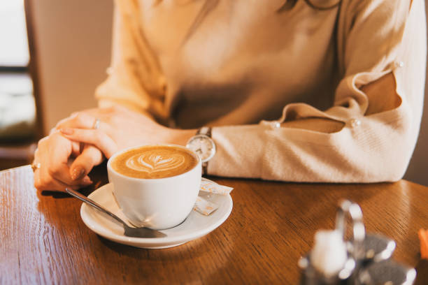 istock A girl drinks latte coffee at a wooden table. 1849224243