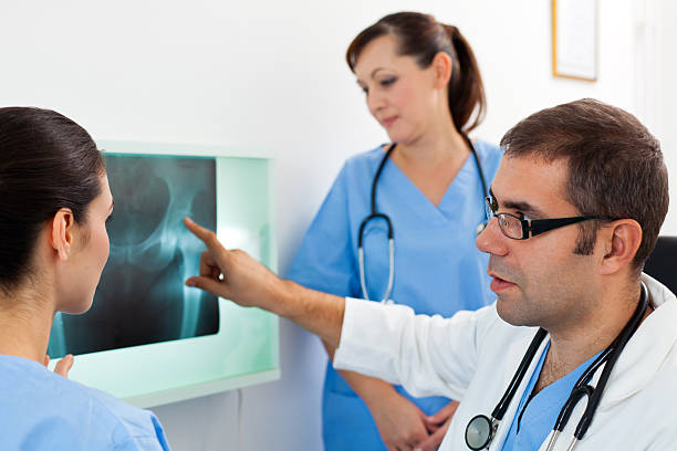 equipo médico examinar imagen de rayos x - x ray image radiologist examining using voice fotografías e imágenes de stock