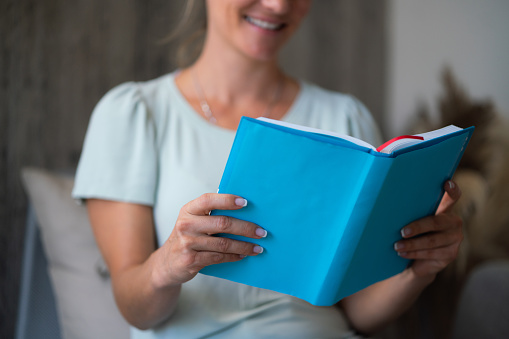 Close-up of woman reading a book at home