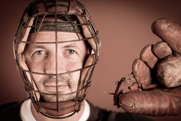 Vintage Baseball Player in Catching Stance with Ball and Mitt