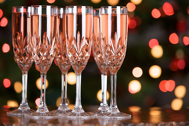 verres de champagne rose avec des lumières en arrière-plan flou coloré - pink champagne photos et images de collection