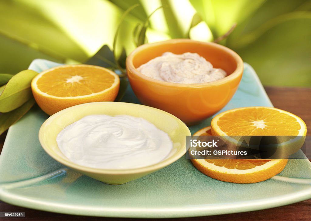 Spa salt scrub esfoliante, olio di massaggio, crema idratante su un piatto - Foto stock royalty-free di Arancia