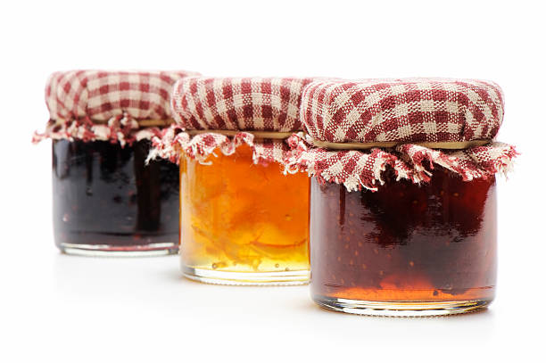 Homemade jellies "Homemade small jars of blackberry, orange and strawberry jellies isolated on white." gelatin dessert stock pictures, royalty-free photos & images