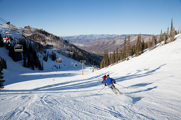 Fast Skiers at Aspen A pair of fast skiers rocket down a groomed trail on Ajax Mountain at Aspen Colorado. aspen colorado photos stock pictures, royalty-free photos & images