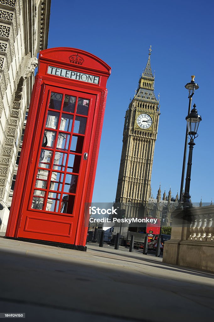 London Red Telephone Box with Big Ben Iconic English red telephone box stands next to a blue sky view of Big Ben Big Ben Stock Photo