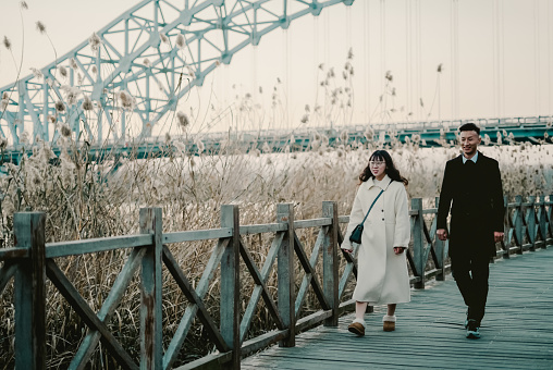 Asian young couple happily walking outdoors in winter