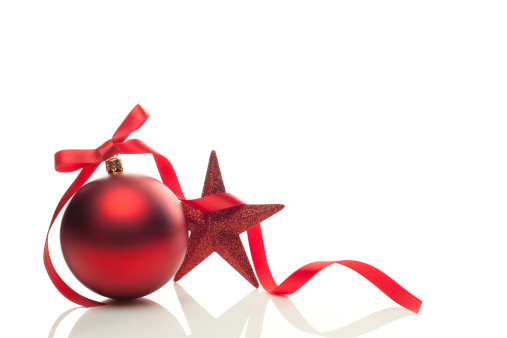 Two red Christmas baubles and curling paper Isolated on a white background