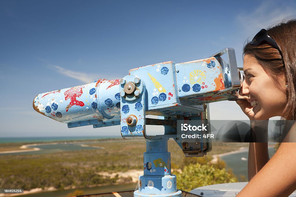 Woman Looking through a Telescope (XXXL) Beautiful female tourist with a perfect candid smile enjoy the stunning view through a telescope. Nikon D3X. Converted from RAW. 20-24 Years Stock Photo