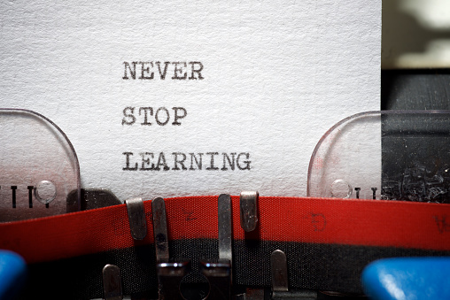 Never stop learning phrase written with a typewriter.